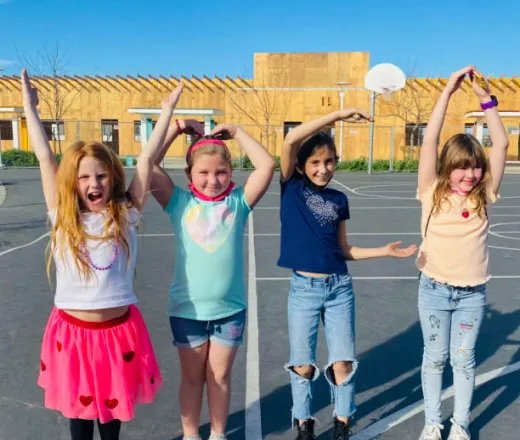 4 girls outside forming Y-M-C-A letters