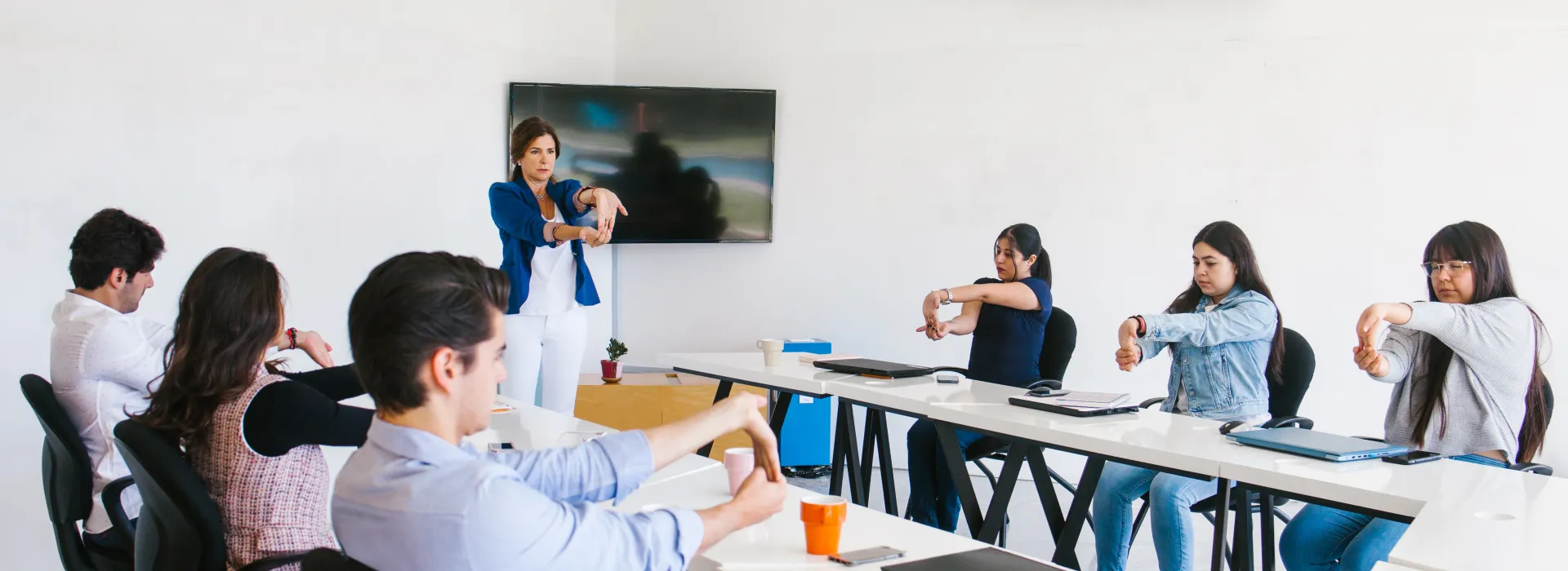 Employees in conference room doing hand stretches